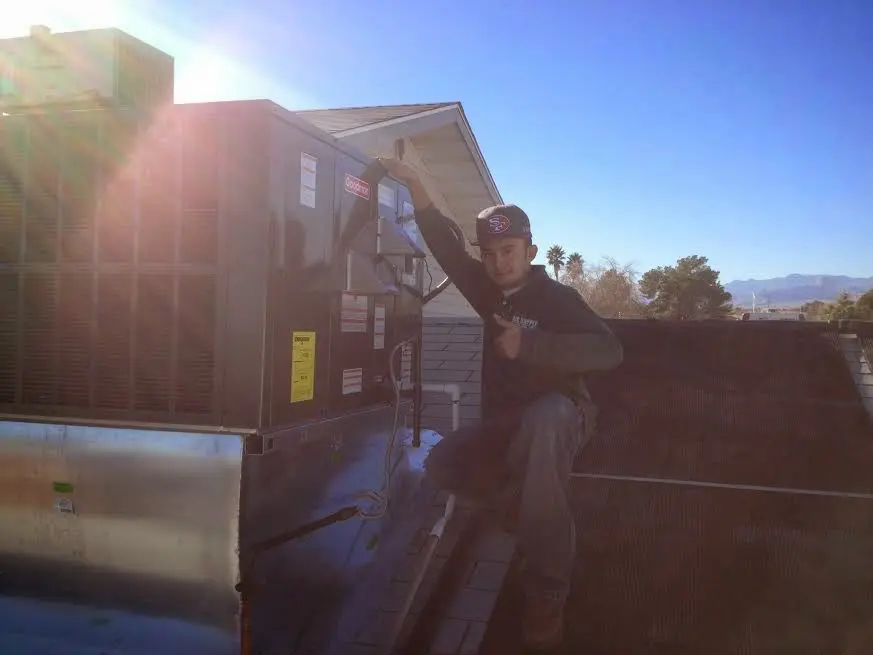 HVAC technician performing Air Duct Cleaning on a rooftop unit in Green Hill